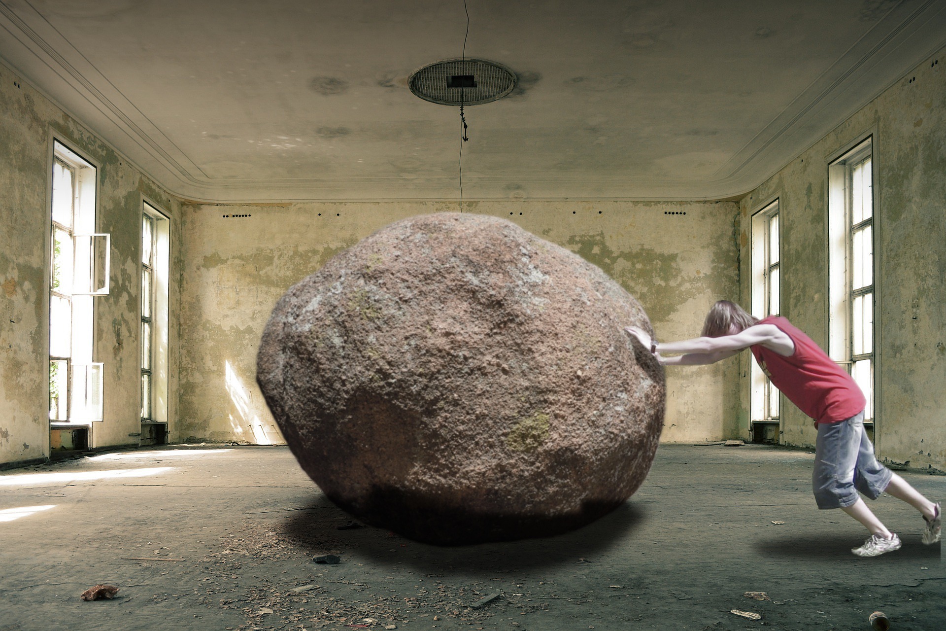 man trying to push boulder